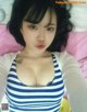 A woman in a blue and white striped shirt laying on a bed.