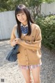 A young woman in a school uniform posing for a picture.