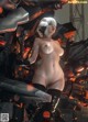 A naked woman standing in front of a giant robot.