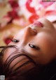 A close up of a woman laying on a bed of flowers.