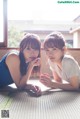 Two young women laying on the floor next to each other.