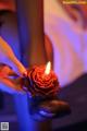 A person holding a red rose in their hand.