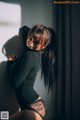 A woman leaning against a wall with her shadow on the wall.