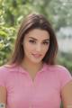 A woman in a pink shirt posing for a picture.