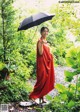 A woman in a red dress holding an umbrella.