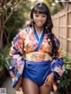 A woman in a blue and orange kimono posing for a picture.