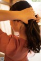 A woman is combing her hair with a comb.