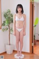 A woman in a white bikini standing on a scale.